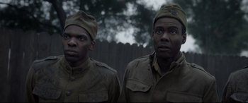 Movie still from “Amsterdam” (2022), directed by David O. Russell – A couple of men standing next to each other; Medium shot, Over the shoulder angle