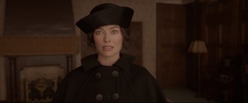 Movie still from “Amsterdam” (2022), directed by David O. Russell – A woman wearing a black hat and a black coat; Close Up shot, Over the shoulder angle