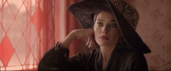 Movie still from “Amsterdam” (2022), directed by David O. Russell – A beautiful woman wearing a hat and posing for a picture; Close Up shot, Over the shoulder angle