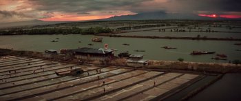 Movie still from “Apocalypse Now” (1979), directed by Francis Ford Coppola – An aerial view of an industrial area near a body of water; Extreme Wide shot, High angle