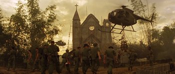 Movie still from “Apocalypse Now” (1979), directed by Francis Ford Coppola – A group of soldiers walking in front of a church; Extreme Wide shot, Low angle