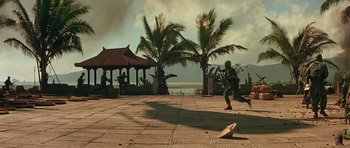 Movie still from “Apocalypse Now” (1979), directed by Francis Ford Coppola – A man running across a brick walkway near a beach; Extreme Wide shot, High angle