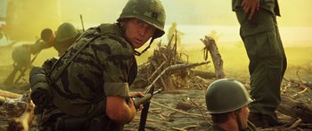 Movie still from “Apocalypse Now” (1979), directed by Francis Ford Coppola – A man in a military uniform holding a rifle; Medium shot, Low angle