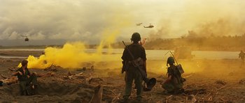 Movie still from “Apocalypse Now” (1979), directed by Francis Ford Coppola – Two soldiers are standing in a field with smoke coming out of the ground; Extreme Wide shot, Low angle