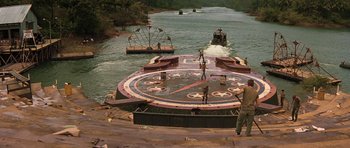 Movie still from “Apocalypse Now” (1979), directed by Francis Ford Coppola – A boat with a clock on it going down a river; Extreme Wide shot, High angle