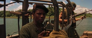 Movie still from “Apocalypse Now” (1979), directed by Francis Ford Coppola – A man with a hat is holding a cell phone in his hand; Close Up shot, Over the shoulder angle