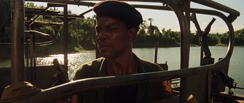 Movie still from “Apocalypse Now” (1979), directed by Francis Ford Coppola – A man wearing a black hat and a green shirt; Close Up shot, Low angle