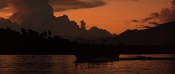Movie still from “Apocalypse Now” (1979), directed by Francis Ford Coppola – A boat sailing on a body of water at sunset; Extreme Wide shot, Low angle