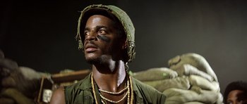 Movie still from “Apocalypse Now” (1979), directed by Francis Ford Coppola – A man in a green hat and a green shirt; Close Up shot, Low angle