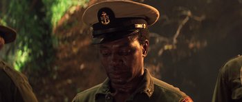 Movie still from “Apocalypse Now” (1979), directed by Francis Ford Coppola – A man in a military uniform wearing a hat and looking down; Close Up shot, Low angle