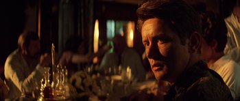 Movie still from “Apocalypse Now” (1979), directed by Francis Ford Coppola – A person sitting at a dinner table; Close Up shot, Over the shoulder angle