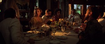 Movie still from “Apocalypse Now” (1979), directed by Francis Ford Coppola – A group of people sitting around a dinner table; Medium shot, High angle
