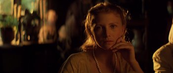 Movie still from “Apocalypse Now” (1979), directed by Francis Ford Coppola – A woman wearing a necklace is looking at the camera; Close Up shot, Over the shoulder angle