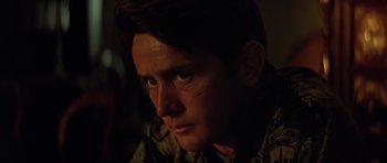 Movie still from “Apocalypse Now” (1979), directed by Francis Ford Coppola – A person looking at the camera; Close Up shot, Over the shoulder angle