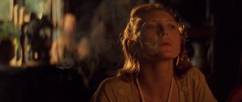 Movie still from “Apocalypse Now” (1979), directed by Francis Ford Coppola – A woman is smoking a cigarette in the dark; Close Up shot, Low angle