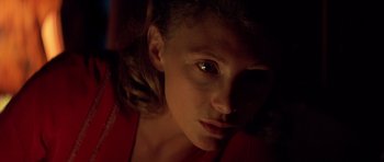 Movie still from “Apocalypse Now” (1979), directed by Francis Ford Coppola – A woman with a dark background looking at the camera; Close Up shot, Low angle