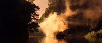 Movie still from “Apocalypse Now” (1979), directed by Francis Ford Coppola – A boat in a body of water near a forest; Extreme Wide shot, High angle