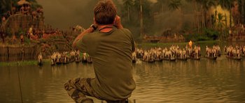 Movie still from “Apocalypse Now” (1979), directed by Francis Ford Coppola – A man sitting in front of a body of water; Wide shot, Over the shoulder angle