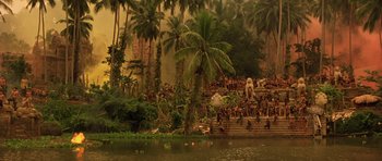 Movie still from “Apocalypse Now” (1979), directed by Francis Ford Coppola – A group of people standing on steps next to a body of water; Extreme Wide shot, High angle