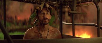 Movie still from “Apocalypse Now” (1979), directed by Francis Ford Coppola – A shirtless man with a leaf hat on his head; Close Up shot, High angle