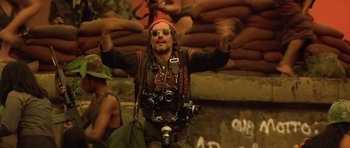 Movie still from “Apocalypse Now” (1979), directed by Francis Ford Coppola – A man with a camera in his hands; Medium shot, Low angle