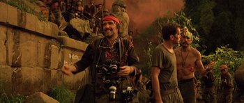 Movie still from “Apocalypse Now” (1979), directed by Francis Ford Coppola – A man holding a pair of binoculars while standing next to another man; Medium shot, Low angle