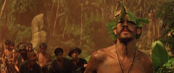 Movie still from “Apocalypse Now” (1979), directed by Francis Ford Coppola – A group of men standing next to each other in front of a painting; Medium shot, Low angle