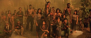 Movie still from “Apocalypse Now” (1979), directed by Francis Ford Coppola – A group of people standing in a room with guns; Wide shot, Low angle