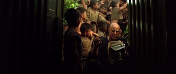 Movie still from “Apocalypse Now” (1979), directed by Francis Ford Coppola – A group of people standing around each other in a room; Medium shot, High angle