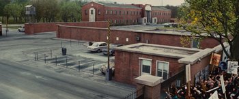 Movie still from “Argo” (2012), directed by Ben Affleck – An aerial view of an industrial area with a car parked on the side of the road; Extreme Wide shot, High angle