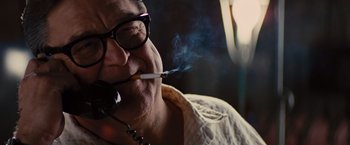 Movie still from “Argo” (2012), directed by Ben Affleck – A man smoking a cigarette while wearing glasses; Close Up shot, Low angle
