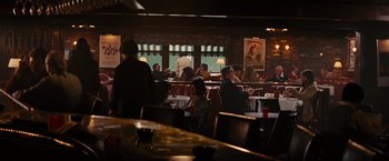 Movie still from “Argo” (2012), directed by Ben Affleck – People are sitting at tables in a restaurant; Wide shot, Over the shoulder angle
