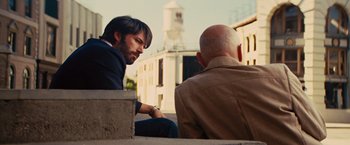 Movie still from “Argo” (2012), directed by Ben Affleck – A man sitting on a bench next to another man; Medium shot, Over the shoulder angle