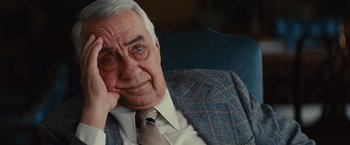 Movie still from “Argo” (2012), directed by Ben Affleck – An older man sitting in a chair with his head resting on his hand; Close Up shot, Over the shoulder angle
