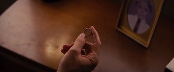 Movie still from “Argo” (2012), directed by Ben Affleck – A person holding a ring in their hand; Extreme Close Up shot, Overhead angle