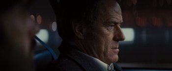 Movie still from “Argo” (2012), directed by Ben Affleck – An older man in a suit and tie looking to his left; Close Up shot, Over the shoulder angle