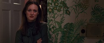 Movie still from “Argo” (2012), directed by Ben Affleck – A woman standing in front of a floral wallpaper; Close Up shot, Over the shoulder angle