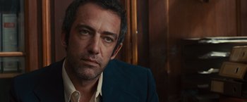 Movie still from “Argo” (2012), directed by Ben Affleck – A person wearing a suit and tie; Close Up shot, Over the shoulder angle