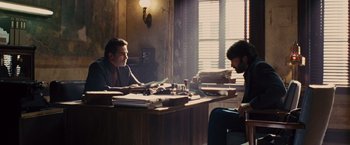 Movie still from “Argo” (2012), directed by Ben Affleck – Two people sitting at a desk in a room; Wide shot, Low angle