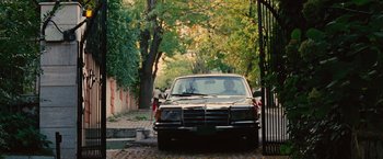 Movie still from “Argo” (2012), directed by Ben Affleck – A black car parked in front of a tree; Wide shot, High angle