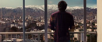 Movie still from “Argo” (2012), directed by Ben Affleck – A man standing on a balcony looking out at the mountains; Wide shot, Over the shoulder angle