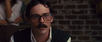 Movie still from “Argo” (2012), directed by Ben Affleck – A man wearing glasses and a black vest; Close Up shot, Low angle