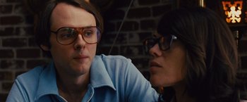 Movie still from “Argo” (2012), directed by Ben Affleck – A man and a woman sitting next to each other wearing glasses; Close Up shot, Low angle
