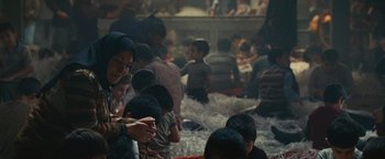 Movie still from “Argo” (2012), directed by Ben Affleck – A group of people gathered in a large room; Medium shot, Over the shoulder angle