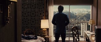 Movie still from “Argo” (2012), directed by Ben Affleck – A man standing in front of a window looking outside; Wide shot, Low angle