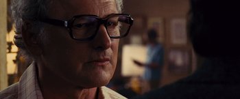 Movie still from “Argo” (2012), directed by Ben Affleck – An older man wearing glasses looking at the camera; Close Up shot, Over the shoulder angle