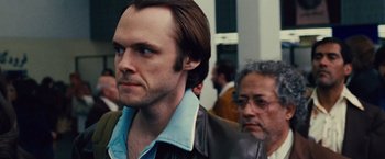 Movie still from “Argo” (2012), directed by Ben Affleck – A man with a goatee is looking to his left; Close Up shot, Over the shoulder angle