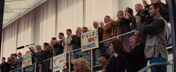 Movie still from “Argo” (2012), directed by Ben Affleck – A group of people standing in a stadium holding signs; Wide shot, High angle