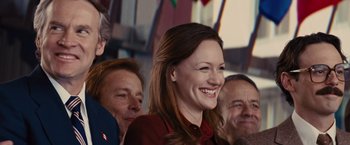 Movie still from “Argo” (2012), directed by Ben Affleck – A group of people sitting next to each other and smiling; Close Up shot, Low angle