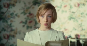 Movie still from “Atonement” (2007), directed by Joe Wright – A young girl with blue eyes is holding a book; Close Up shot, Over the shoulder angle